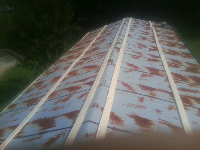 Rusted metal roof panels with new wood purlins before replacement — Storm Damage Roof Repair in Lake Grove by Roofing Brothers